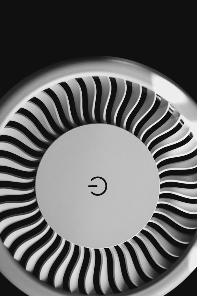 Black and white image of a circular fan with a prominent power symbol.